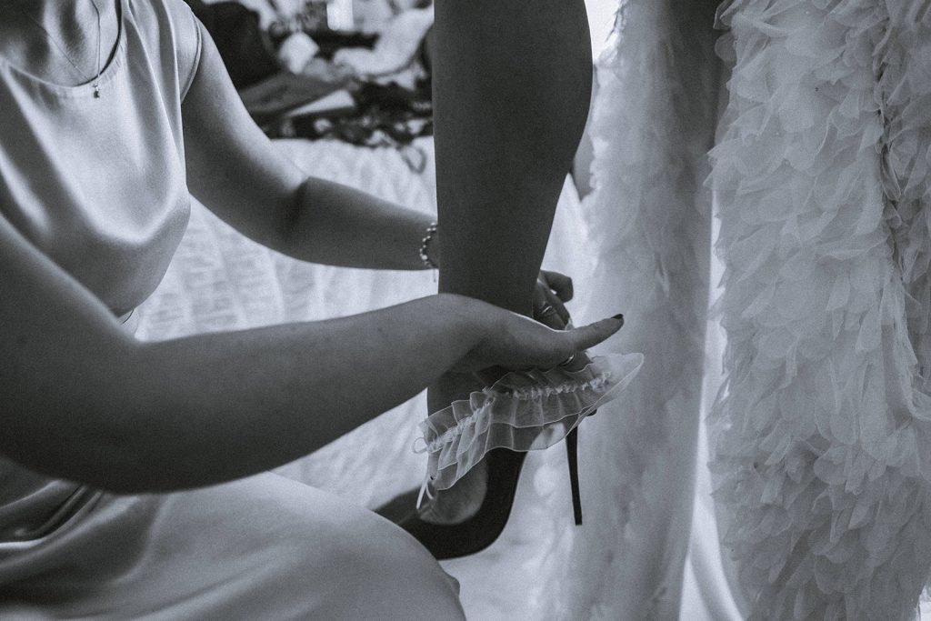 Bride putting on her garter.
